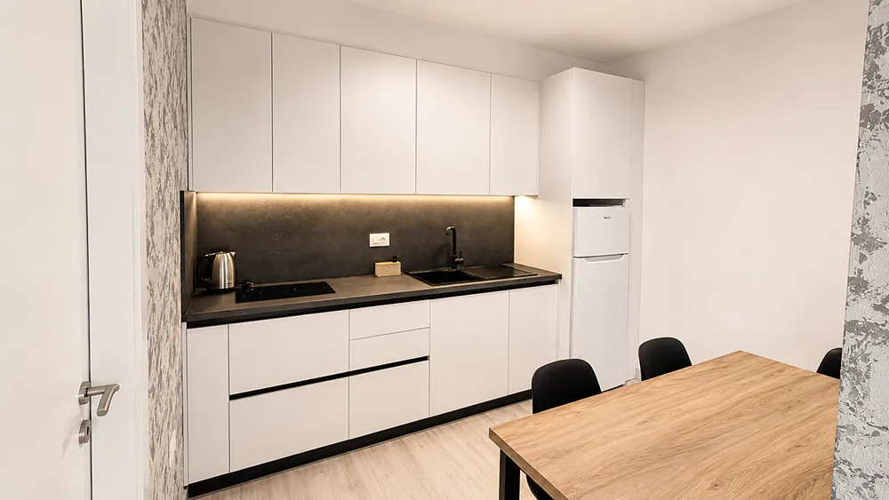 Moderní prakticky vybavená kuchyň v apartmánu s jídelním stolem